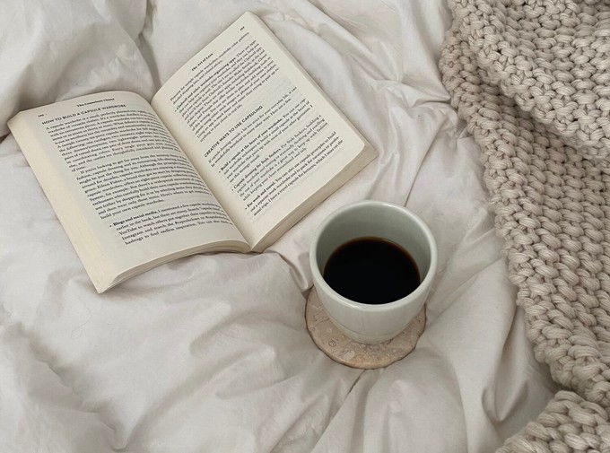 Cosy bed view with a hot drink and a book