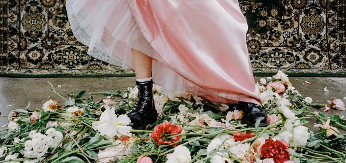 Someone wearing leather boots next to some flowers to introduce the concept of sustainable leather