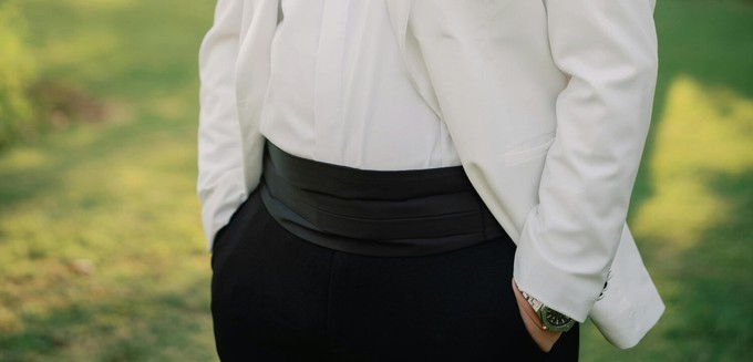 Man wearing a cummerbund which came from an Indian clothing trend