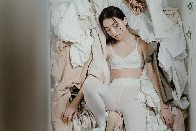 Consumer in front of a wardrobe full of fast fashion clothes