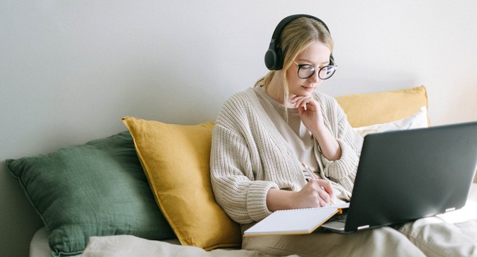 Consumer using her laptop and listening to a podcast on sustainable fashion
