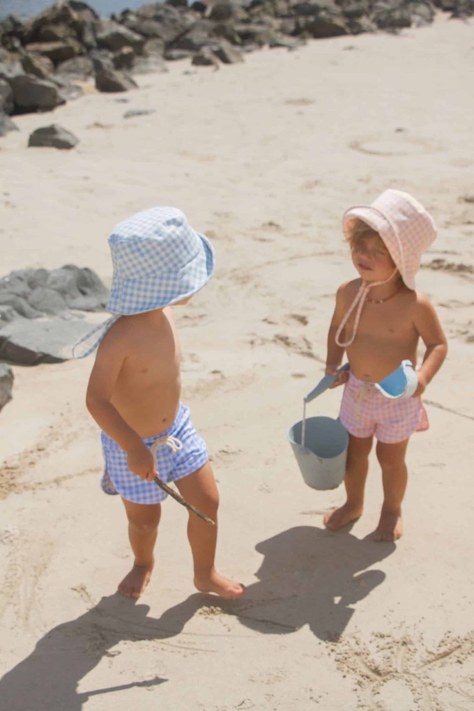 Kids wearing sustainable swimwear for children by the beach
