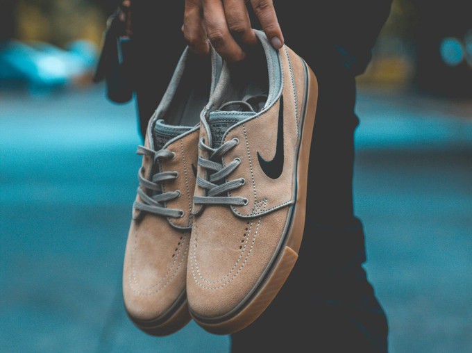 Someone holding a pair of Nike shoes