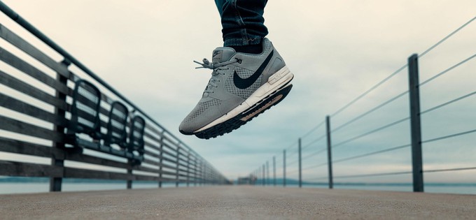 Someone jumping while wearing Nike shoes