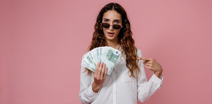 Consumer holding money to showcase the different cost per wear of a sustainable fashion wardrobe